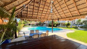 Un patio con mesa y sillas y una piscina. en The Villa of Dreams, en Cancún