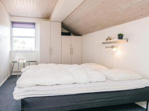 ヘンネ・ストランドにあるTranquil Oasis in Henne Strand-By Traumの木製天井の客室で、白い大型ベッド1台が備わります。 +25枚の写真