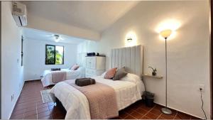 Dos camas en una habitación con paredes blancas. en The Villa of Dreams, en Cancún 38 fotos más
