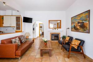 a living room with a couch and a fireplace at Casa das Conchas in Carvoeiro