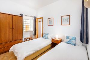a bedroom with two beds and a cabinet at Casa das Conchas in Carvoeiro