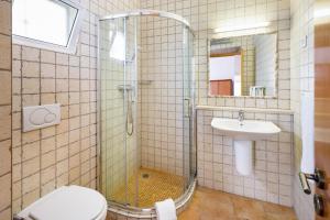 a bathroom with a shower and a toilet and a sink at Casa das Conchas in Carvoeiro +22 photos