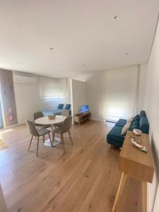 a living room with a blue couch and a table at AVEIRO WONDER STAY in Aveiro +8 photos