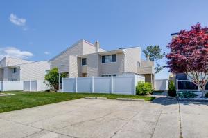 a house with a white fence in a yard at Walk to Brigantine Beach Condo with Furnished Patio in Brigantine