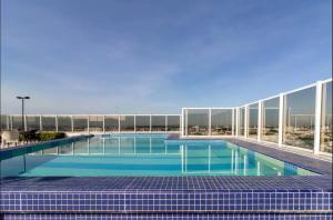 a large swimming pool on top of a building at Apartamento Localizado em Guarulhos com excelente estrutura in Guarulhos