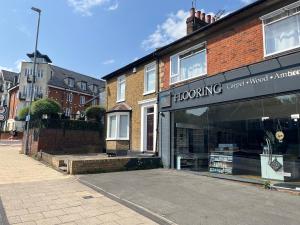 ein Geschäft vor einem Gebäude auf einer Straße in der Unterkunft Yugogo One-Bedroom Apartment 37 London Road in St Albans