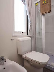 グラードにあるMobilehome in Grado 53448のトイレ、洗面台、窓のあるバスルーム