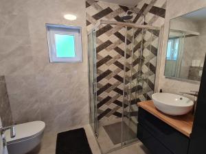 een badkamer met een wastafel en een glazen douche bij Holiday home in Gruda 43517 in Gruda +24 foto's