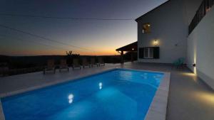 a swimming pool in front of a house at night at Holiday home in Dolenja Vas - Istrien 51848 in Dolenja Vas