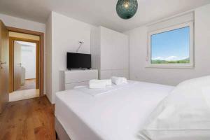 a white room with two beds and a television at Holiday home in Tribalj 51443 in Tribalj +60 photos