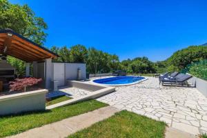 a backyard with a swimming pool and a patio at Holiday home in Tribalj 51443 in Tribalj