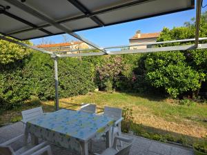 stół i krzesła pod pergolą na patio w obiekcie Appartamento verde w mieście Porto Azzurro