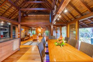 a dining room with a wooden table and chairs at Fare Makana in Maharepa +24 photos