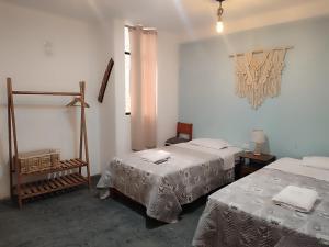 a room with two beds and a window and a room with two beds at Hospedaje Velilu in Ica