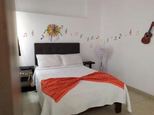 a bedroom with a bed with a red scarf on it at Manuel Muñiz in Morelia