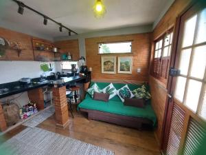 a living room with a green couch in a room at Chalé do Canto - Pé da Serra in Lima Duarte
