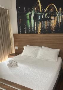 a bed with a pair of slippers on top of it at Águas Claras in Brasilia