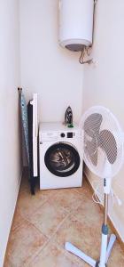 a laundry room with a washing machine and a fan at COSTA ROSSA - Relax vista mare, nel Nord Sardegna in Cascabraga