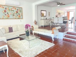 Una sala de estar con muebles blancos y una mesa. en The Villa of Dreams, en Cancún