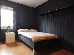 a bedroom with a bed with black walls and a window at Margaret's Home in Nøtterøy