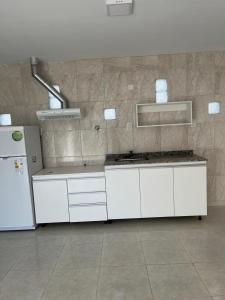 a kitchen with white cabinets and a refrigerator at La casa de Beatriz Paz, confort y tranquilidad in San Rafael