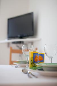 a table with two wine glasses and a tv at Apartments Baričević in Bol