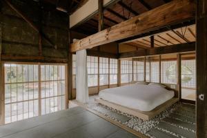 Nagara紡ノ座 築100年 一日一組限定のモダン古民家ステイ的带窗户的房间里有一张床的卧室