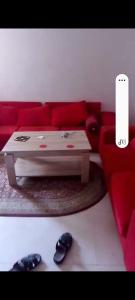 a living room with a red couch and a coffee table at Mansbay in O Ben Slimane
