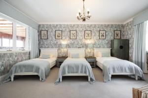 a bedroom with two beds and a chandelier at Loch View House in Kilfinan +12 photos