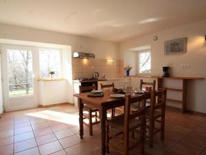 a kitchen with a wooden table and chairs in it at Gîte rénové au calme avec Parking privé et Wifi gratuit à Saint-Étienne-Lardeyrol - FR-1-582-332 in Saint-Étienne-Lardeyrol