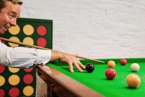 a man playing a game of snooker on a pool table at Tamar Castle in St Mellion