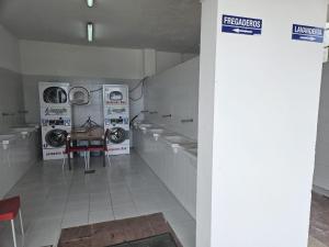 a laundry room with washing machines and a table in it at Albergue Camping de Castro in Castro-Urdiales