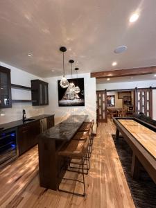 Una cocina con pisos de madera, encimeras y mesas. en Serenity at Sherwood - Mid Term Rental, en Breckenridge