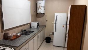 a kitchen with a white refrigerator and a sink at Departamento 3 in Santa Rosa