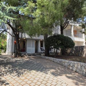 a house with trees in front of a driveway at Holiday house with a parking space Baska, Krk - 24681 in Baška