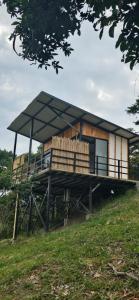 a house with a roof on top of a field at Cabañas Mariluna in Estación El Salto
