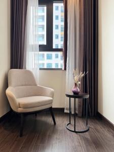 a chair and a table in front of a window at Lavender House- The Sapphire Resident 2 in Ha Long