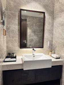 a bathroom with a white sink and a mirror at Lavender House- The Sapphire Resident 2 in Ha Long