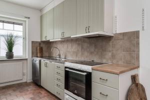 a kitchen with white cabinets and a sink at Gylle Luxe Retreat in Borlänge