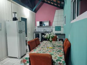 una cocina con una mesa y un refrigerador en Apto com churrasqueira 500m do mar com vista da salaSacada para horizonte, en São Francisco do Sul 23 fotos más