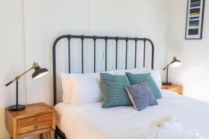 a bedroom with a bed with pillows and two lamps at Victorian Gem Close to Petco Park & Gaslamp in San Diego