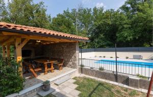 Un pabellón con una mesa y una piscina. en 2 Bedroom Gorgeous Apartment In Tribalj, en Tribalj