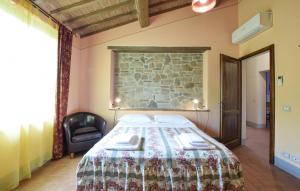 Un dormitorio con una cama con una pared de piedra. en Stunning Home In Lucignano, en Lucignano