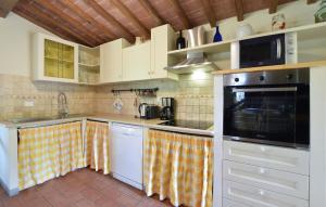 Una cocina con gabinetes blancos y un horno de estufa. en Stunning Home In Lucignano, en Lucignano
