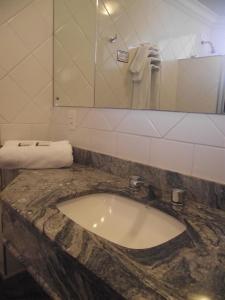 y baño con lavabo de mármol y espejo. en Augustus Plaza Hotel en Sao Jose do Rio Preto