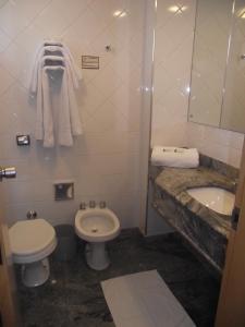 a bathroom with a toilet and a sink at Augustus Plaza Hotel in Sao Jose do Rio Preto