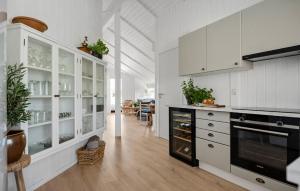 a kitchen with white cabinets and a black stove at Stunning Home In Odder With Sauna in Odder