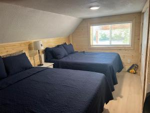 a bedroom with two beds and a window at glacier creek apartment in Seward