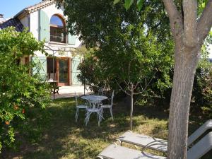 a table and chairs in the yard of a house at Captivating Holiday Home in Les Vans with Pool in Les Vans