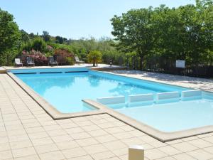 a large swimming pool with blue water at Captivating Holiday Home in Les Vans with Pool in Les Vans +73 photos